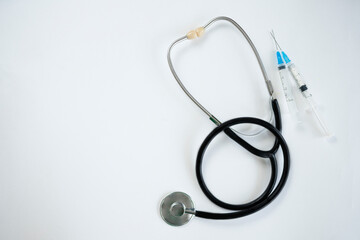 Stethoscope, syringe and thermometer close-up, on a white background. Selective focus, copy space. View from above. Cardiology concept