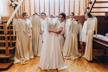Cheerful, young, attractive witnesses next to the bride. Wedding preparations. Fitting dresses.