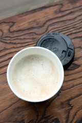 Hot Coffee in take away cup on wooden table
