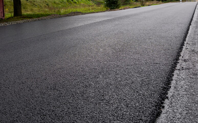 A large layer of fresh hot asphalt. Layer of asphalt raw material in a shallow depth of field....