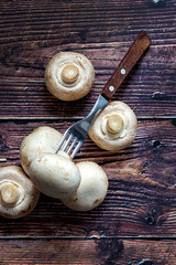 Fresh Mushrooms on wooden background with fork