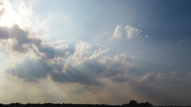 Cumulus clouds covering the Sun causing strong shadows and light rays, Tyndall Effect.