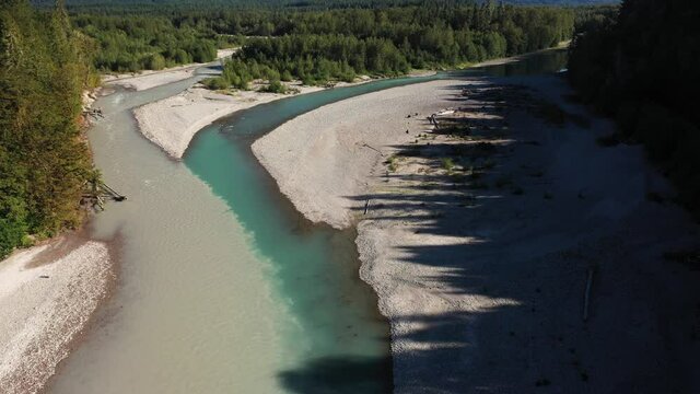Aerial View of River Confluence in Green Forested Landscape of Washington State USA. Fusion of Muddy and Clear Turquoise Alipine Water, Drone Shot