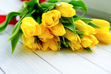 Bouquet of yellow tulips flowers on white wooden background. Waiting for spring. position, top view.