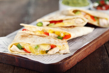 Still life on wood with chicken quesadillas, guacamole and pico de gallo. Macro vision