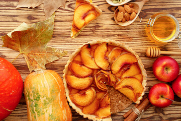 Obraz na płótnie Canvas Apple tart pie and red apples on wooden table
