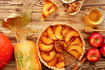 Apple tart pie and red apples on wooden table