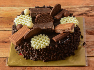 Freshly made choco fantasy cream cake on wooden table. selective focus