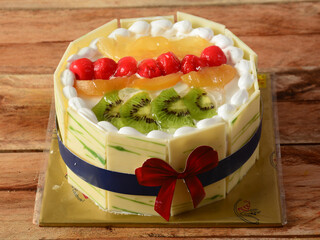 Freshly made Mix fruit cream cake on wooden table. selective focus