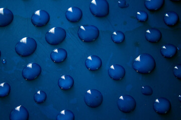 Water drops on dark surface. Abstract background.  Natural pattern close up photo. 
