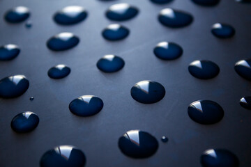 Water drops on dark surface. Abstract background.  Natural pattern close up photo. 
