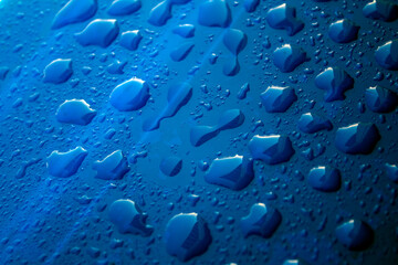 Water drops on dark surface. Abstract background.  Natural pattern close up photo. 
