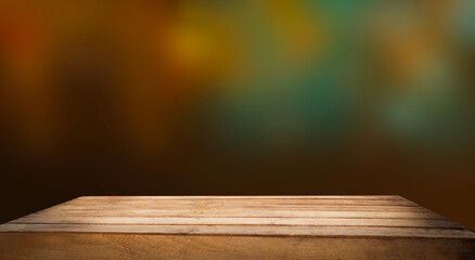 Empty wooden table top on blur light golden bokeh of cafe restaurant, bar in a dark background.