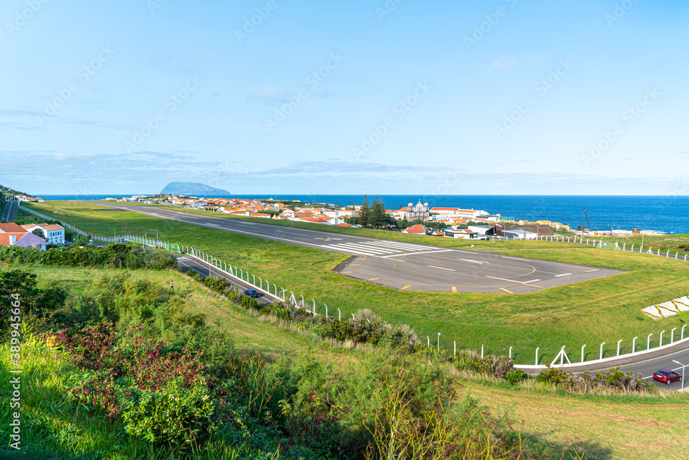 Wall mural azores, island of graciosa, view at the airport of santa cruz da graciosa. th runway is near houses 