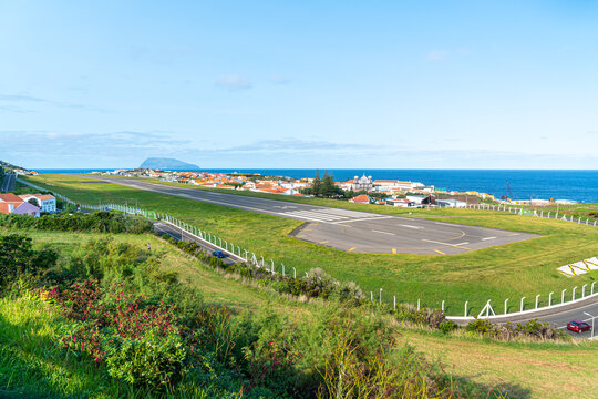 Azores, island of Graciosa, view at the airport of Santa Cruz da Graciosa. th runway is near houses and church.