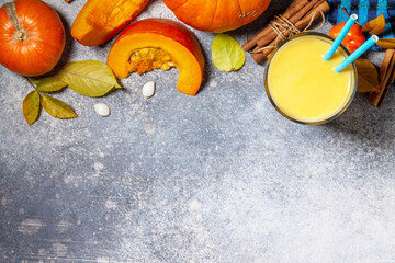Healthy Autumn pumpkin smoothie with cinnamon in glass on a stone countertop. Top view flat lay background. Copy space.