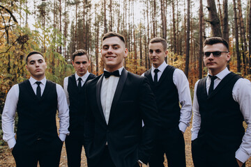 Cheerful, young, energetic witnesses of the groom next to the groom. Friends congratulate the...