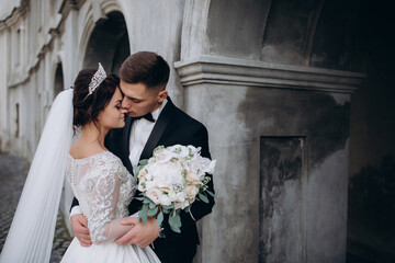 Romantic walk of the groom and the bride through the streets of the city. Photo session with the...
