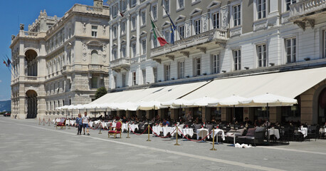 TRIESTE, ITALY - Jun 20, 2018: Piazza Unita d'Italia, Trieste, Italy, including outdoor tables of a cafe