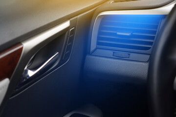Car air conditioning concept. Cold air from the vent panel grille of a modern car.
