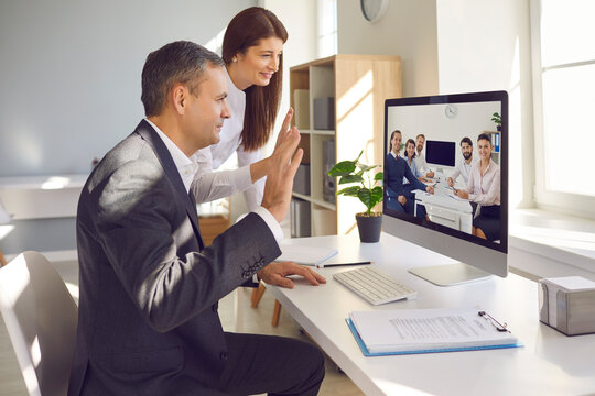 Teams of happy company workers from different departments having video conference