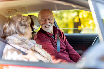 Happy Senior Couple travelling in their car
