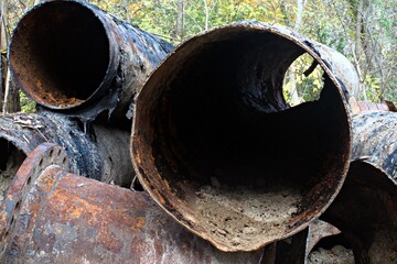 a lot of cut old metal rusted large diameter pipes
