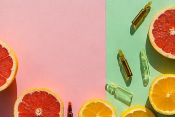 Ampoules with botox, hualuronic, collagen or vitamins on pastel background.Vitamin C Injection Concept.glass ampules and fresh citrus fruits.Face Serum. Prevention,Health and beauty. Strong immunity.