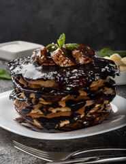 Pancakes and pancakes. Traditional pancakes with chocolate and banana on a dark background.