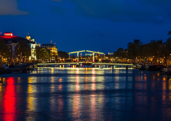 Fototapeta na wymiar Puente luminioso en un canal de Amsterdam al anochecer