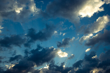 Fototapeta premium Dramatic clouds with sunlight beams. partly cloudy sky. silhouette of clouds at sunset.