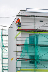 demolition of scaffolding after thermal insulation and painting of the facade of an apartment house