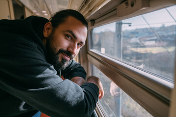 The man looks out the window on the train