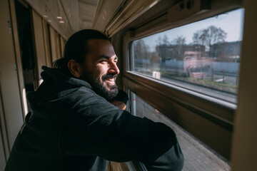 The man looks out the window on the train