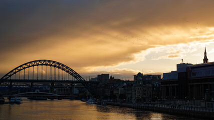 Fototapeta na wymiar Golden rays bursting through clouds at sunset over Newcastle upon Tyne
