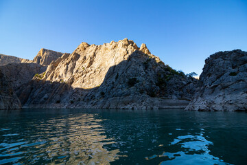 Fototapeta na wymiar Boat tour on the river in the canyon. Cliffs of the canyon from the level of river ground. canyon at sunset.