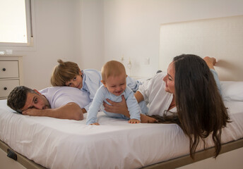 Fototapeta premium Portrait Of Happy Family Wearing Pajamas In Bed. Family Playing In Bed With Her Children. Family Lifestyle.