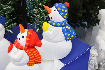 Christmas installation. cute snowmen on the background of the Christmas tree. traditional christmas...