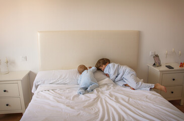 Brothers Playing On The Bed In Pajamas. Family Lifestyle