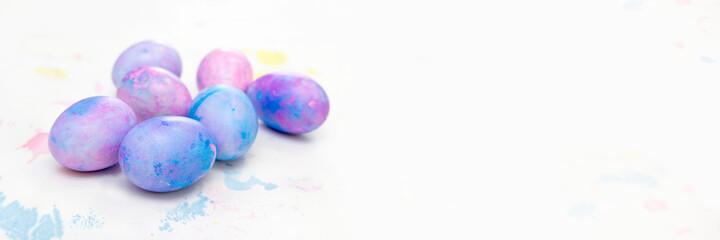banner with Easter eggs and space for writing. Blue and purple eggs