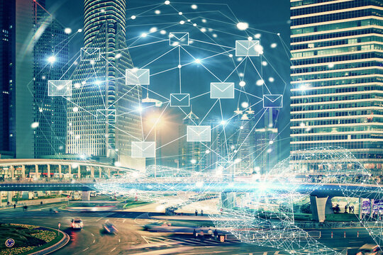 Double exposure of envelop hologram flying from gadget and city view background. Concept e-mail.