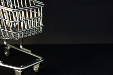 Shopping cart on a black background. The concept of sales and discounts. Black Friday.