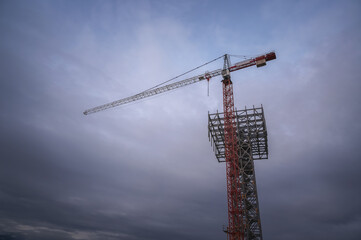 Tower crane on the background of the evening overcast sky