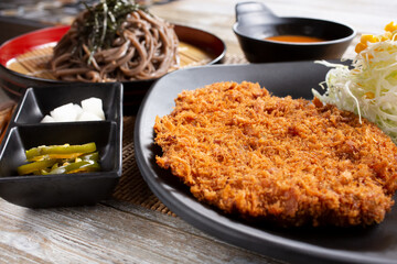 A view of a plate of katsu, and a side of cold soba noodles.