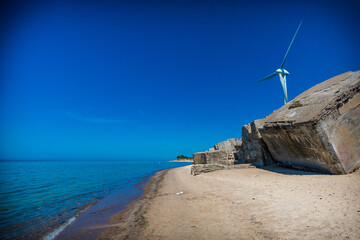 Old war fort ruins on the beach with a wind turbine. Liepaja, Latvia