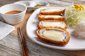 A closeup view of a plate of cheese chicken katsu.