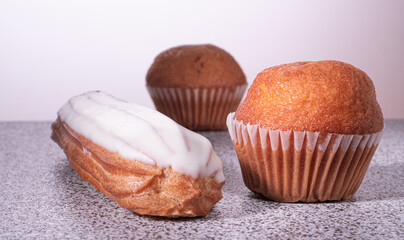 ruddy muffins in a paper cup and eclairs