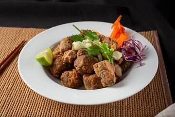 A view of a plate of deep fried garlic beef short rib.