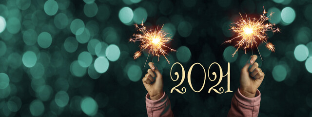 Happy New Year 2021 background banner panorama - Happy girl hold sparkling sparklers in her hands...