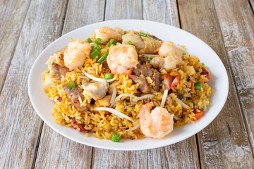 A view of a plate of meat fried rice, featuring shrimp, pork, and beef.